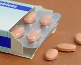 Opakowanie tabletek, kilka sztuk poza blistrem. Należy pamiętać o potencjalnych pitamet skutkach ubocznych.