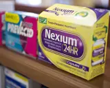 Leki na refluks: opakowania Nexium 24HR i Prevacid 24HR na półce aptecznej.