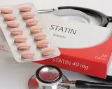 Opakowanie tabletek statynowych i blister z tabletkami. Stetoskop w tle. Statyny na co? Na obniżenie cholesterolu.