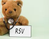 Miś z stetoskopem i tabliczką "RSV". Choć kojarzy się z dziećmi, objawy RSV u dorosłych mogą być groźne.