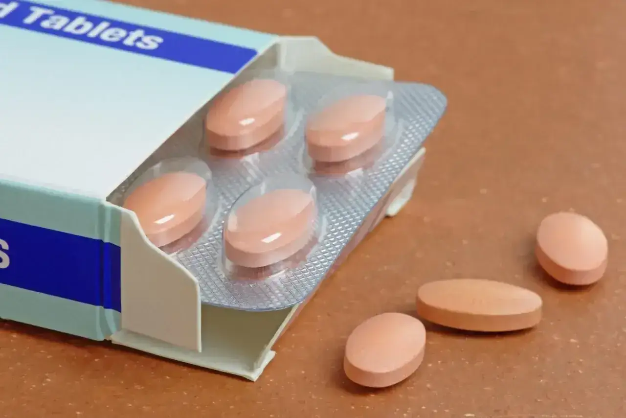 Opakowanie tabletek, w tym pitamet 4 mg, z kilkoma tabletkami w blistrze i kilkoma luźno leżącymi.